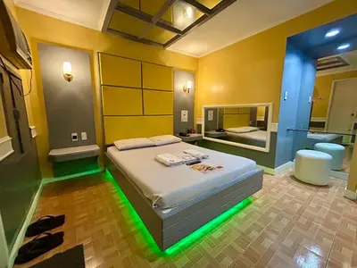 a bedroom with a bed with green lights on it at Town and Country Reposo in Manila