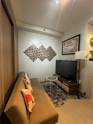 a living room with a couch and a flat screen tv at SMDC Good Stays Shore 2 - Unit 1289 Tower 2 in Manila