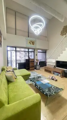 a living room with a green couch and a piano at The Gramercy Residences Unit for Rent in Manila