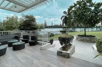 a patio with a bunch of chairs and trees at Cozy aesthetic stay near Alabang in Manila