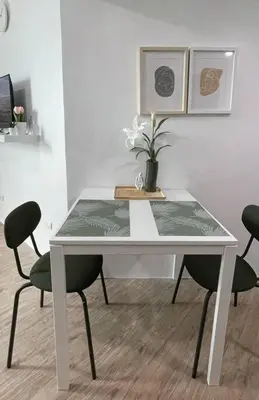 a white table with chairs and a vase of flowers on it at Cozy aesthetic stay near Alabang in Manila