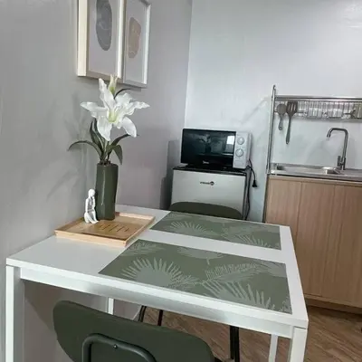 a white table with a vase of flowers and a tv at Cozy aesthetic stay near Alabang in Manila