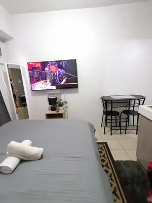 a bedroom with a bed and a tv on the wall at pierrecondotel in Manila