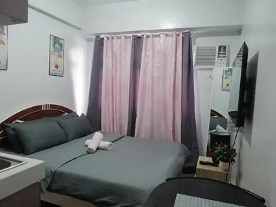 a bedroom with a bed with a teddy bear on it at pierrecondotel in Manila