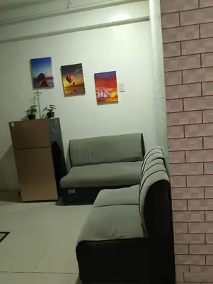 a living room with a couch and a brick wall at Kassel DORZ Hostel Bldg 16 Condostaycation in Manila