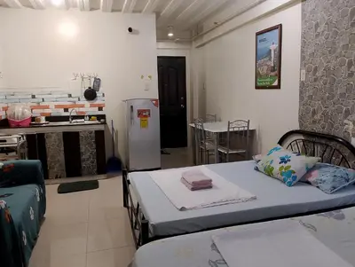 a room with a bed and a kitchen with a refrigerator at Kassel DORZ Hostel Bldg 16 Condostaycation in Manila