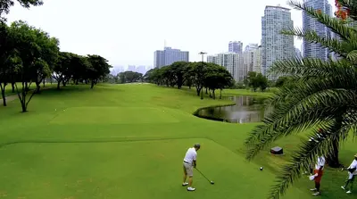 a man is playing golf in a park at Luxury Apartment with PA, Skyline View & Top Amenities in Manila