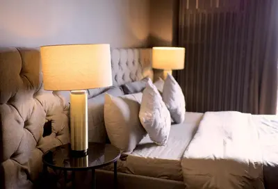 a hotel room with a couch and two lamps at Luxury Apartment with PA, Skyline View & Top Amenities in Manila