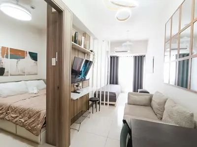 a bedroom with a bed and a couch in a room at Condo in Pasay near MOA PICC World Trade Center in Manila
