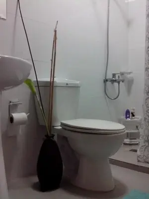 a white bathroom with a toilet and a sink at Monteluce Condominium Apartment in Silang