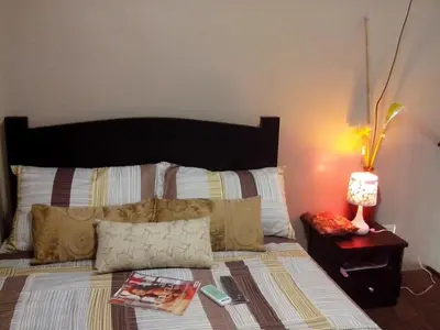 a bedroom with a bed with a lamp on a table at Monteluce Condominium Apartment in Silang
