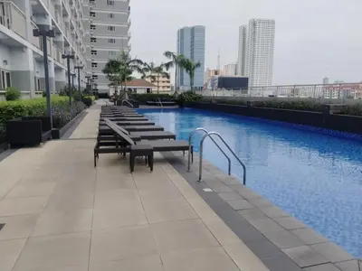 a row of benches sitting next to a swimming pool at 2br Condo Coast Residence near MOA NAIA Ayala WTC in Manila