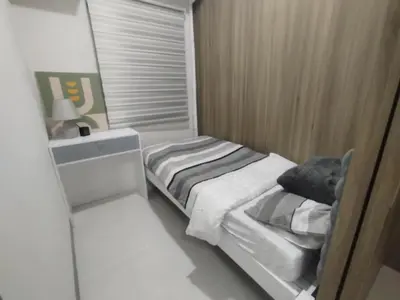 a small bedroom with a bed and a sink at 2br Condo Coast Residence near MOA NAIA Ayala WTC in Manila