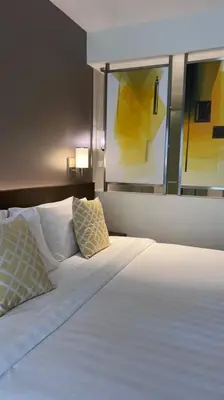 a bedroom with a bed with two pillows on it at Staycation at ACQUA The Hotel Residences Novotel Tower in Manila
