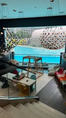 a room with a pool and a table and a swing at Staycation at ACQUA The Hotel Residences Novotel Tower in Manila