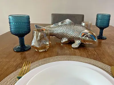 a fish statue on a table with a plate and glasses at Marina- Avant BGC parking w fee in Manila