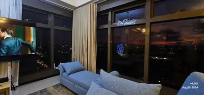a living room with a couch and a large window at Serenity by Zen Residences at The Radiance Manila Bay in Manila