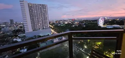 a view of a city at night from a balcony at Serenity by Zen Residences at The Radiance Manila Bay in Manila