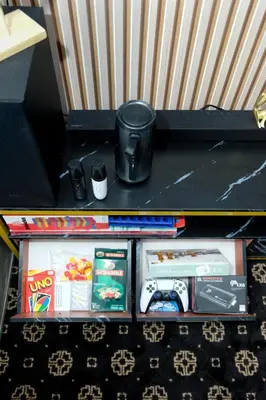 a black shelf with toys and games on it at Nordic Place Fame Residences 75 Smart Amenities Alexa 200mbps Wifi Netflix in Manila
