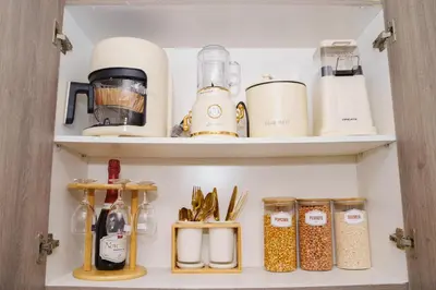 a cupboard filled with lots of kitchen items at Nordic Place Fame Residences 75 Smart Amenities Alexa 200mbps Wifi Netflix in Manila