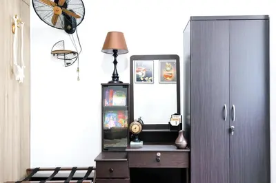 a dresser with a mirror and a lamp next to a cabinet at Nordic Place Fame Residences 75 Smart Amenities Alexa 200mbps Wifi Netflix in Manila