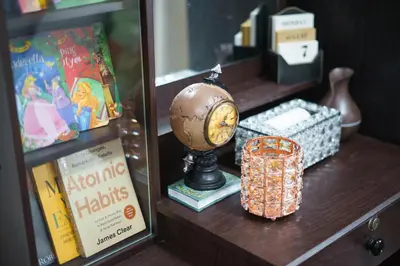 a wooden shelf with a clock and books on it at Nordic Place Fame Residences 75 Smart Amenities Alexa 200mbps Wifi Netflix in Manila