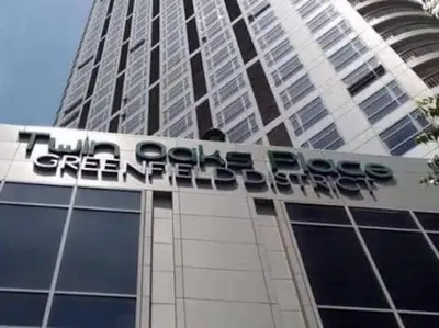 a tall building with a sign on top of it at Twin Oaks Place West Tower in Manila