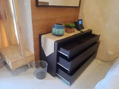a bedroom with a dresser with a vase on it at Twin Oaks Place West Tower in Manila