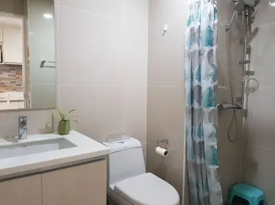 a bathroom with a toilet and a sink and a shower at Twin Oaks Place West Tower in Manila