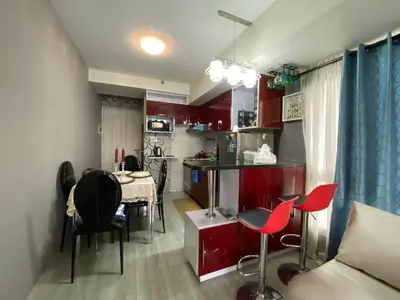 a kitchen with red cabinets and a table and chairs at Casa Maria in Manila