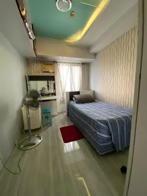 a bedroom with a bed and a desk with a fan at Casa Maria in Manila