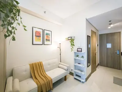 a living room with a couch and a book shelf at GemstoneBR in SMDC Fame Residences in Manila