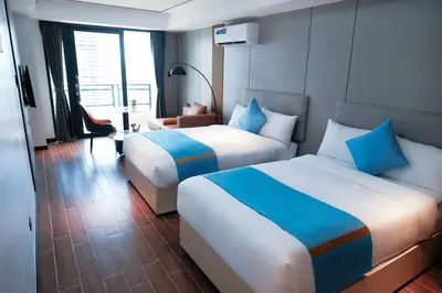 a hotel room with two beds and a table at Golden Seagulls Hotel in Manila