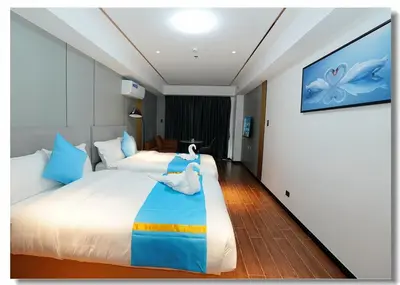 a bedroom with a large white bed with blue pillows at Golden Seagulls Hotel in Manila