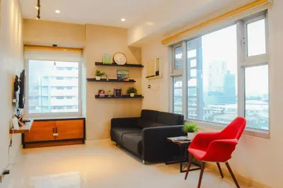 a living room with a couch and a red chair at Stylish 1BR Near US Embassy & Luneta with Pool & Gym in Manila