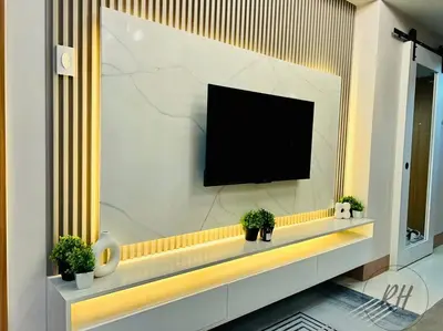 a flat screen tv on a wall with potted plants at Minimalist and Serene 1BR Condo Unit near MOA in Manila