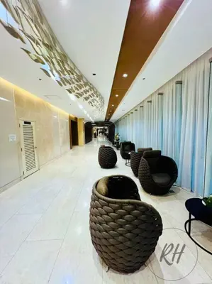 a lobby with a row of chairs in a building at Minimalist and Serene 1BR Condo Unit near MOA in Manila