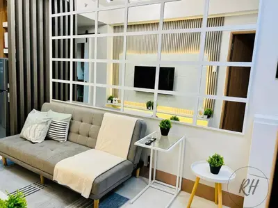 a living room with a couch and some windows at Minimalist and Serene 1BR Condo Unit near MOA in Manila