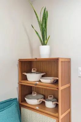 a wooden shelf with bowls and a potted plant at Tree of Life Penthouse 3BR w Gym Pool Sauna More in Manila