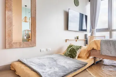 a bedroom with a bed and a mirror on the wall at Tree of Life Penthouse 3BR w Gym Pool Sauna More in Manila