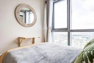 a bedroom with a mirror and a bed and a window at Tree of Life Penthouse 3BR w Gym Pool Sauna More in Manila