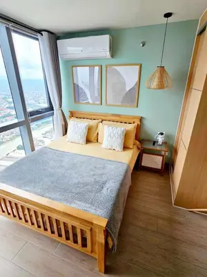 a bedroom with a large bed in a room with windows at Tree of Life Penthouse 3BR w Gym Pool Sauna More in Manila