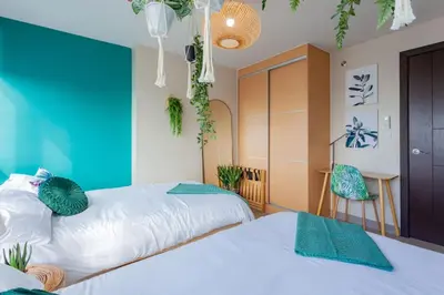 two beds in a room with blue walls and plants at Urban Oasis Serenity in the City w Pool Gym More in Manila