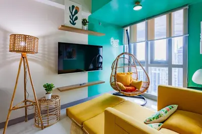 a living room with a couch and a hanging chair at Urban Oasis Serenity in the City w Pool Gym More in Manila