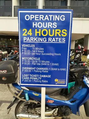 a sign on a motorcycle parked in a parking lot at Comfy 19 shore2 Residence Free parking, Near Airport, IKEA, MOA, Pasay City in Manila