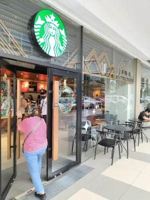 a woman walking in front of a restaurant at Comfy 22 shore2 Residence Free parking, Near Airport, IKEA, MOA, Pasay City in Manila