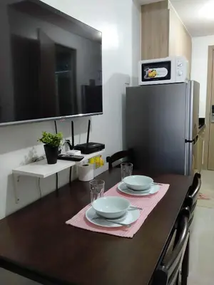 a kitchen with a table with two plates and a refrigerator at Comfy 22 shore2 Residence Free parking, Near Airport, IKEA, MOA, Pasay City in Manila