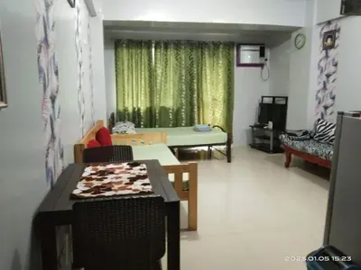 a living room with a couch and a table in front of a window at Hungary109 Service Apartments Near Airport at Kassel Residences in Manila