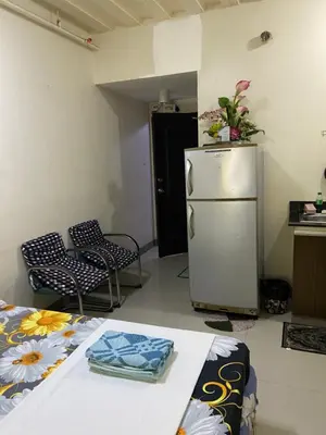 a room with a refrigerator and two chairs and a table at Hungary109 Service Apartments Near Airport at Kassel Residences in Manila