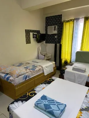 a small room with two beds and a table at Hungary109 Service Apartments Near Airport at Kassel Residences in Manila